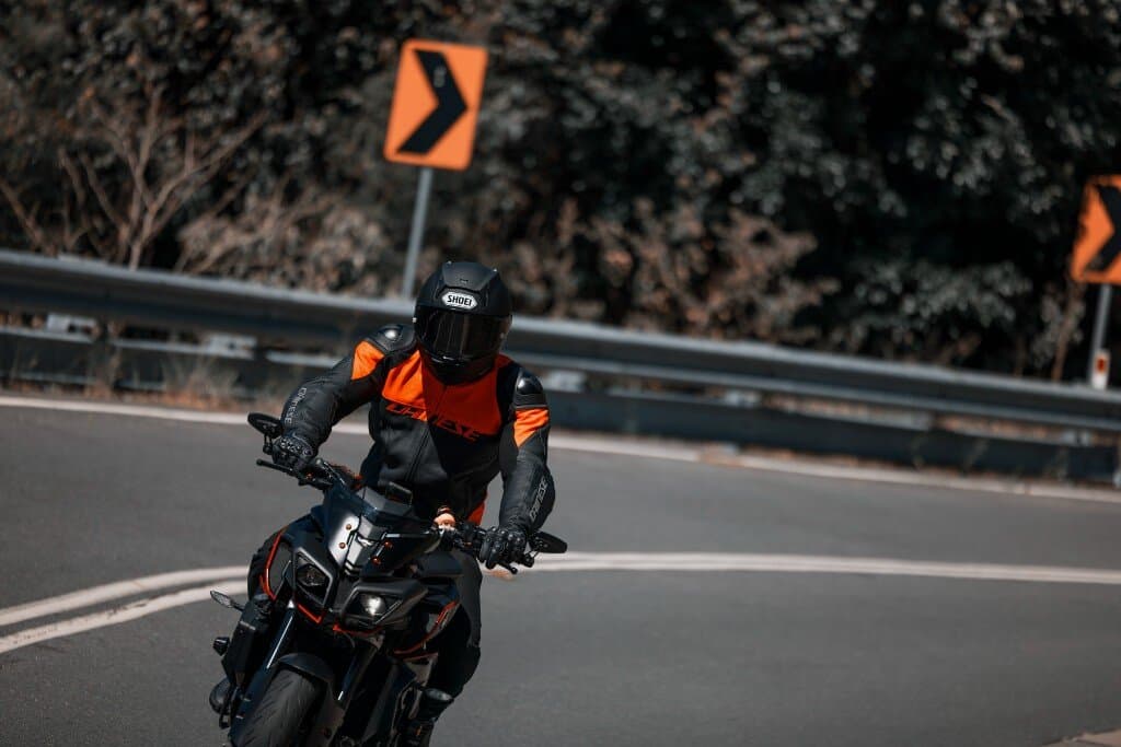 Motorcyclist in Dainese jacket and Shoei helmet riding a Yamaha MT-10 on a winding road