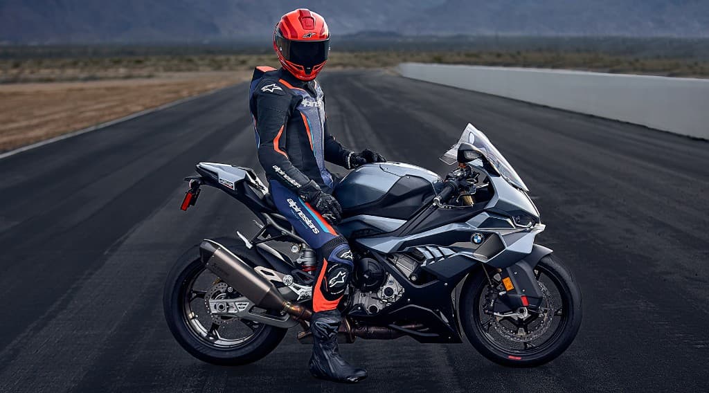 Rider in Alpinestars racing suit and full-face helmet on a BMW S1000RR sportbike